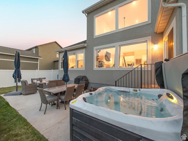667 S Meade St, Mapleton, UT 84664 - patio terrace at dusk with outdoor dining space, fence, an outdoor hangout area, and a hot tub