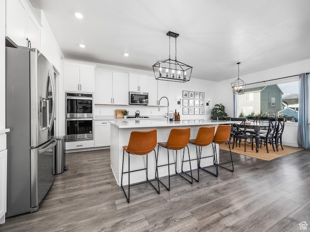 667 S Meade St, Mapleton, UT 84664 - kitchen featuring a breakfast bar, dark wood-style flooring, light countertops, and appliances with stainless steel finishes