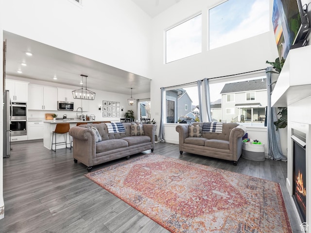 667 S Meade St, Mapleton, UT 84664 - living area with a high ceiling, dark wood-style floors, a warm lit fireplace, and recessed lighting