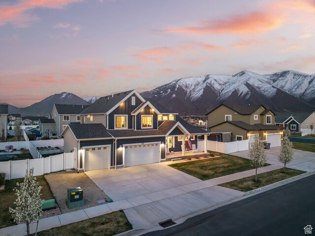 view of front facade with driveway, a mountain view, and fence