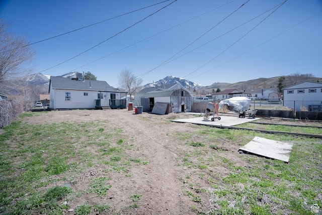 190 S Broadway St, Tooele, UT 84074 - view of yard with a shed, a fenced backyard, a mountain view, and an outbuilding