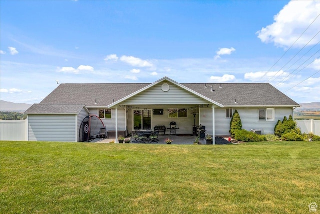 rear view of property with a patio, roof with shingles, cooling unit, fence, and a lawn
