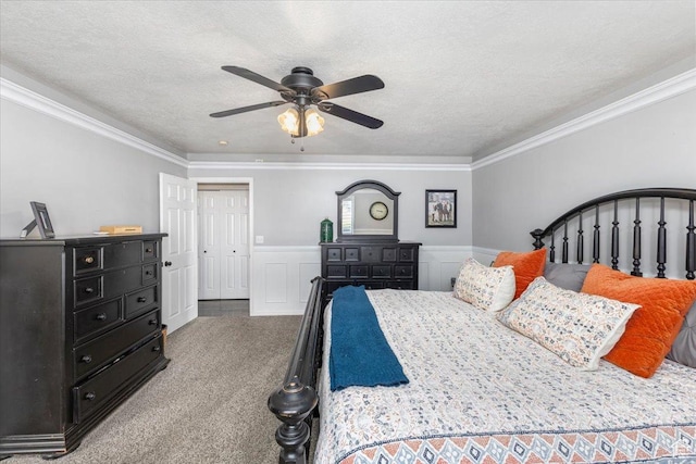carpeted bedroom featuring a textured ceiling, ornamental molding, and a wainscoted wall