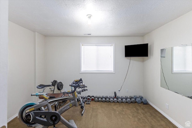 workout area with visible vents, carpet, and a textured ceiling