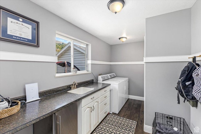 clothes washing area with separate washer and dryer, dark wood-style flooring, a sink, baseboards, and cabinet space