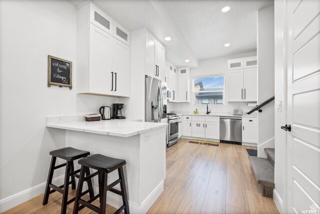 3567 N Lakeview Ct, Eden, UT 84310 - kitchen featuring light wood-style floors, a breakfast bar, a sink, and stainless steel appliances