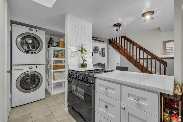 490 E Tonalea Dr, Murray, UT 84107 - kitchen with gas stove, stacked washer and clothes dryer, light tile patterned floors, white cabinetry, and decorative backsplash