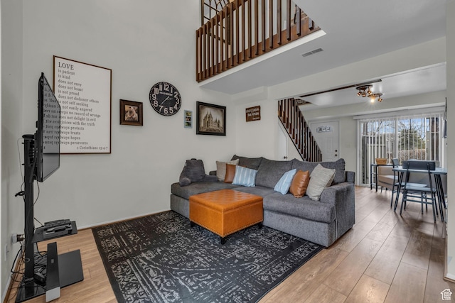 490 E Tonalea Dr, Murray, UT 84107 - living area featuring a towering ceiling, baseboards, stairway, visible vents, and wood finished floors