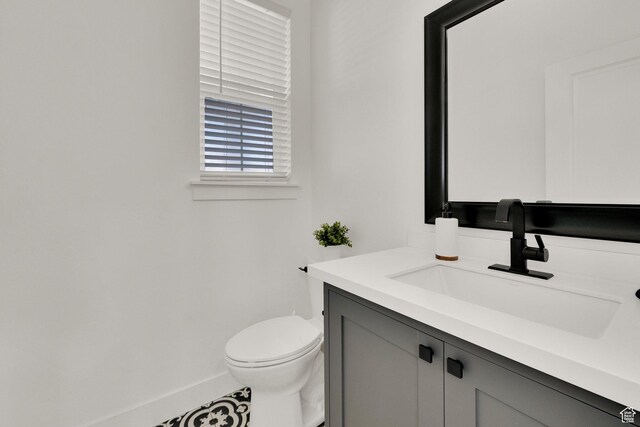 bathroom featuring vanity, baseboards, and toilet