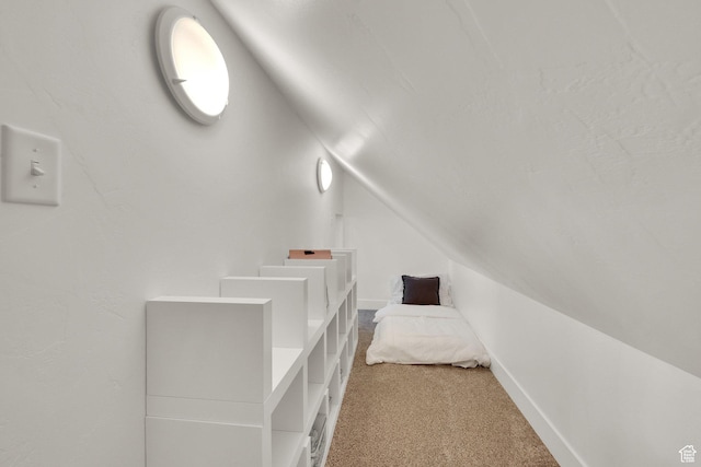 unfurnished bedroom with vaulted ceiling and carpet floors