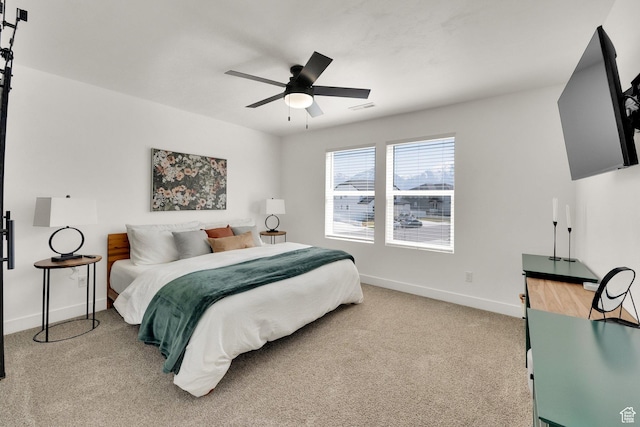 bedroom featuring light colored carpet, baseboards, a ceiling fan, and visible vents
