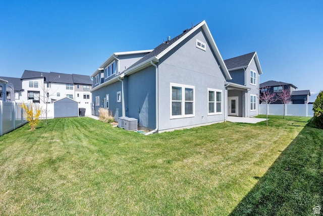 back of property featuring central AC, a yard, a fenced backyard, stucco siding, and a patio area