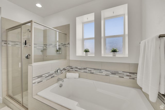 bathroom featuring a shower stall and a garden tub