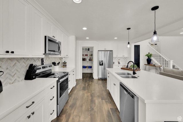 kitchen featuring light countertops, decorative backsplash, a sink, and stainless steel appliances