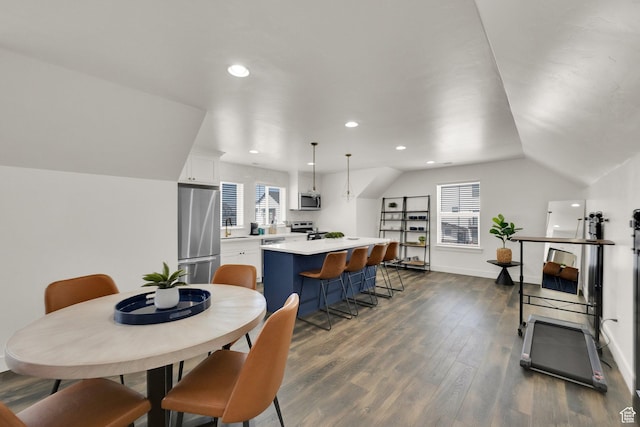 dining room featuring dark wood-type flooring, a healthy amount of sunlight, and recessed lighting
