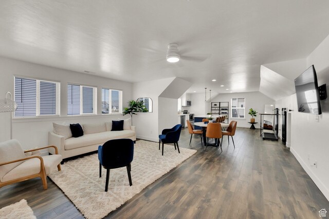 living area with dark wood-style flooring, baseboards, and a ceiling fan