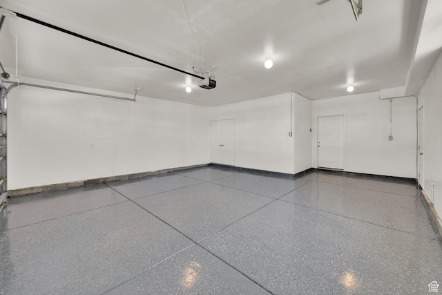 garage with baseboards and a garage door opener