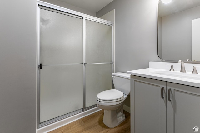 2710 S Highland Dr Unit 11, Salt Lake City, UT 84106 - bathroom featuring toilet, a stall shower, wood finished floors, and vanity