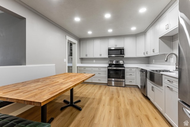 2710 S Highland Dr Unit 11, Salt Lake City, UT 84106 - kitchen featuring a sink, light countertops, appliances with stainless steel finishes, recessed lighting, and light wood-style flooring