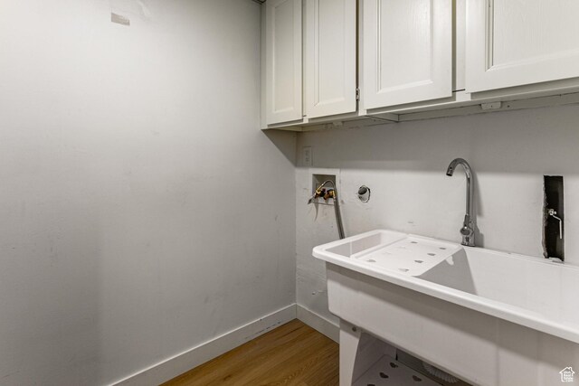 2710 S Highland Dr Unit 11, Salt Lake City, UT 84106 - laundry area featuring hookup for a washing machine, a sink, light wood finished floors, baseboards, and cabinet space