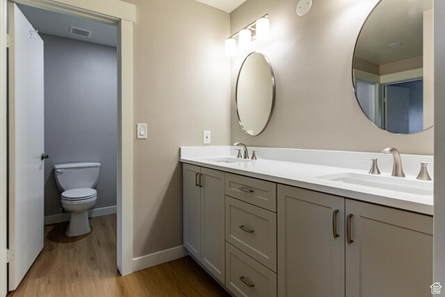 2710 S Highland Dr Unit 11, Salt Lake City, UT 84106 - full bathroom with a sink, toilet, double vanity, and wood finished floors