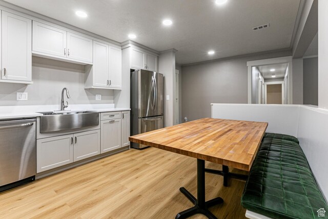 2710 S Highland Dr Unit 11, Salt Lake City, UT 84106 - kitchen with light wood-style flooring, light countertops, visible vents, stainless steel appliances, and a sink