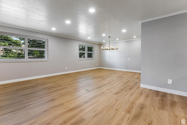 2710 S Highland Dr Unit 11, Salt Lake City, UT 84106 - empty room featuring crown molding, light wood-style floors, an inviting chandelier, recessed lighting, and baseboards