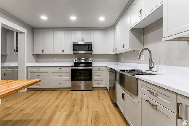 2710 S Highland Dr Unit 11, Salt Lake City, UT 84106 - kitchen featuring a sink, light countertops, recessed lighting, stainless steel appliances, and light wood-style flooring