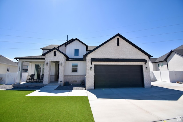 modern farmhouse featuring concrete driveway, board and batten siding, brick siding, a garage, and fence