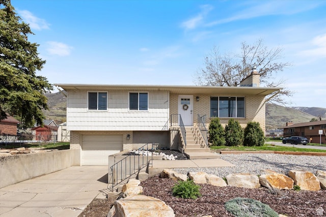 1322 N Main St, Centerville, UT 84014 - view of front of property featuring brick siding, driveway, a chimney, and an attached garage