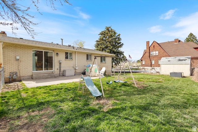 1322 N Main St, Centerville, UT 84014 - back of property featuring a patio, brick siding, an outbuilding, a yard, and a playground