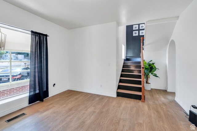 105 W 600 S, Manti, UT 84642 - unfurnished room featuring arched walkways, visible vents, wood finished floors, stairs, and baseboards