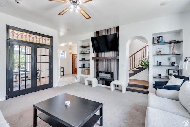 105 W 600 S, Manti, UT 84642 - carpeted living room with built in features, arched walkways, ceiling fan, a fireplace, and stairway