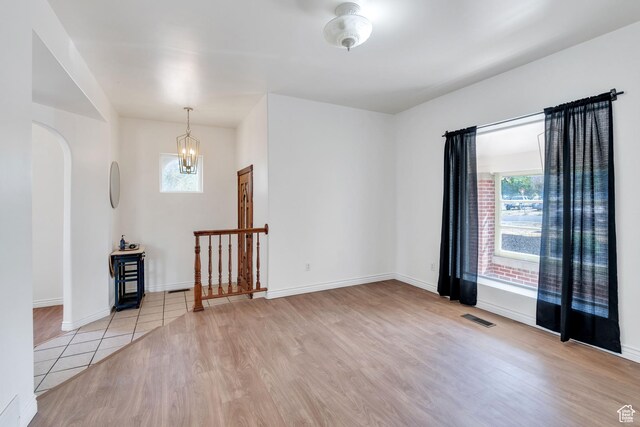 105 W 600 S, Manti, UT 84642 - empty room featuring visible vents, baseboards, arched walkways, a notable chandelier, and light wood finished floors