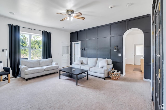 105 W 600 S, Manti, UT 84642 - living area featuring arched walkways, light colored carpet, a decorative wall, and ceiling fan