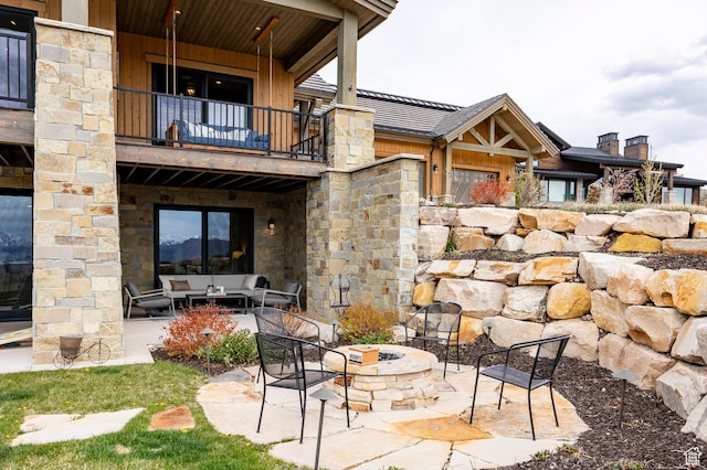 1285 N Oquirrh Mountain Dr, Heber City, UT 84032 - back of property with an outdoor living space with a fire pit, a balcony, a patio, and stone siding