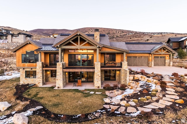 1285 N Oquirrh Mountain Dr, Heber City, UT 84032 - view of front of property with a chimney, a standing seam roof, metal roof, stone siding, and a balcony