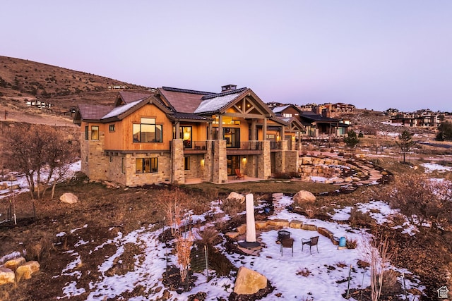 1285 N Oquirrh Mountain Dr, Heber City, UT 84032 - snow covered rear of property featuring a chimney, a balcony, and a tile roof