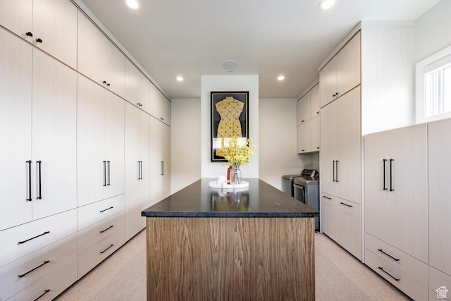 1285 N Oquirrh Mountain Dr, Heber City, UT 84032 - kitchen featuring dark stone counters, recessed lighting, washing machine and dryer, a center island, and light colored carpet