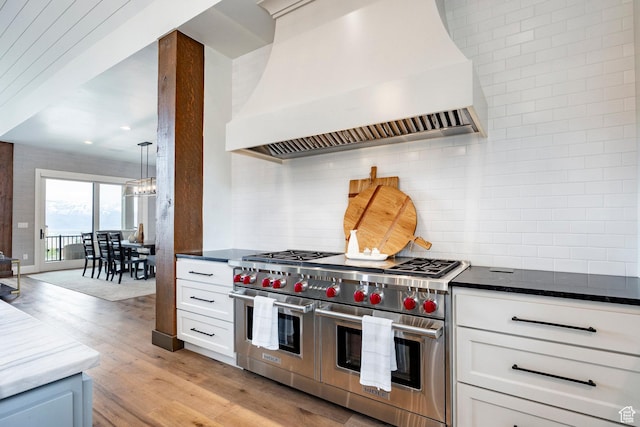 1285 N Oquirrh Mountain Dr, Heber City, UT 84032 - kitchen with tasteful backsplash, light wood-style floors, range with two ovens, an inviting chandelier, and custom exhaust hood