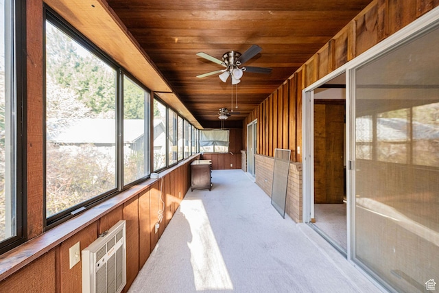 unfurnished sunroom featuring a wall mounted AC and a ceiling fan