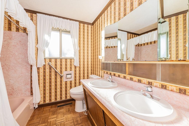 bathroom featuring wallpapered walls, a sink, and vaulted ceiling