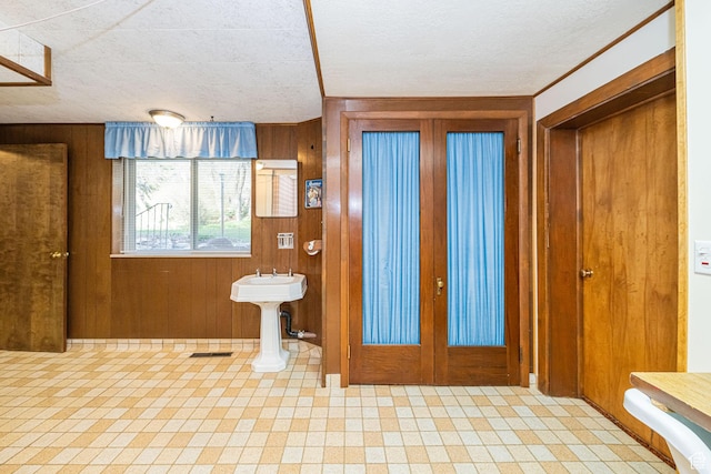 entrance foyer with french doors, visible vents, and wood walls