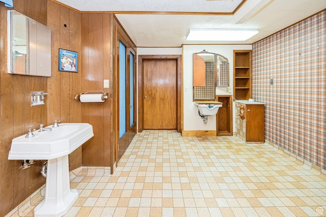 bathroom featuring wooden walls and baseboards