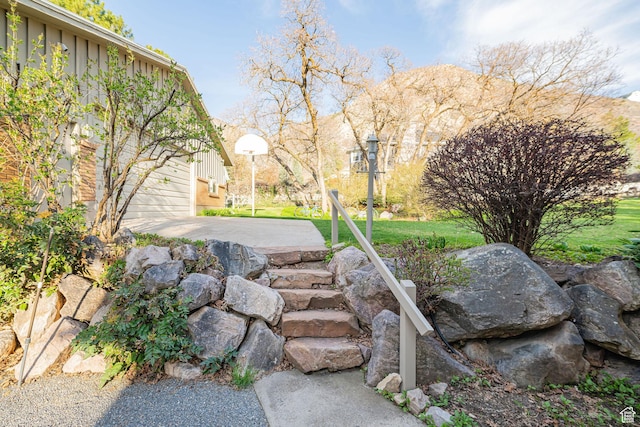 view of community featuring a patio, a yard, and a garage