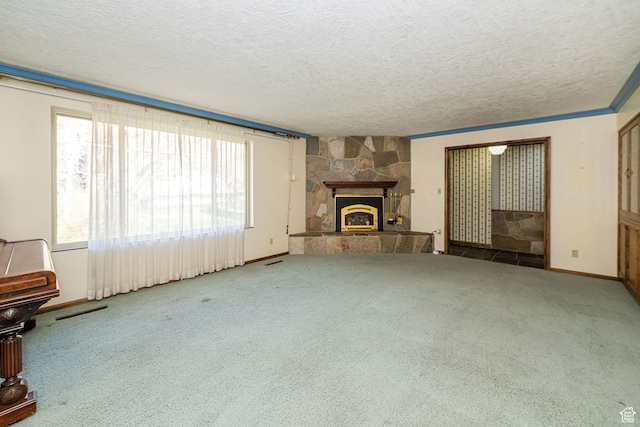 unfurnished living room featuring a stone fireplace, a textured ceiling, and carpet floors