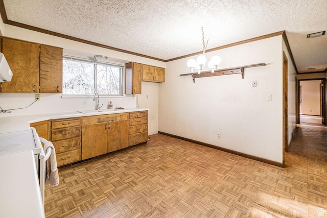 kitchen with a sink, ornamental molding, brown cabinetry, and a textured ceiling