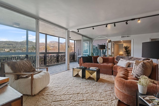 living room with a mountain view, visible vents, and floor to ceiling windows