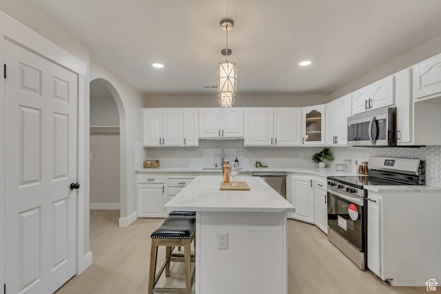 kitchen featuring white cabinets, appliances with stainless steel finishes, and decorative backsplash