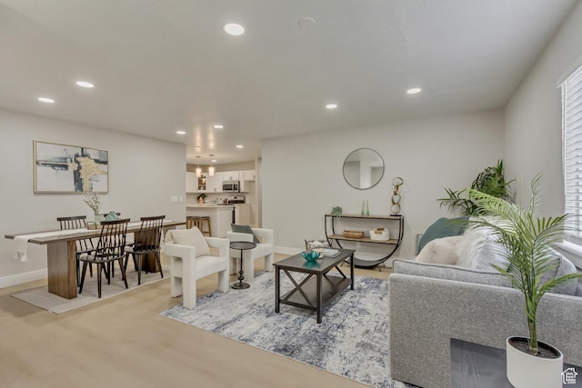 living room featuring recessed lighting, light wood-style flooring, and baseboards
